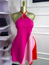 Mannequin wearing a pink and red dress with shelves and shoes in the background