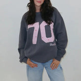 Person wearing a dark gray sweatshirt with '70' printed on it