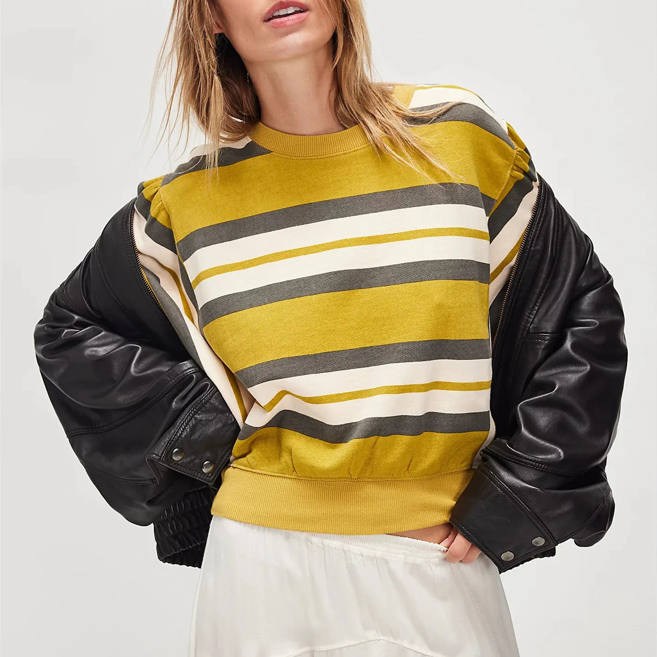 Person wearing a striped sweater with a black leather jacket on a white background