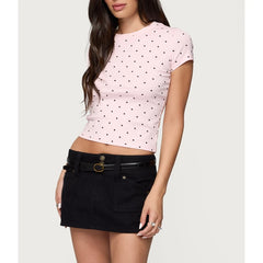 Woman wearing a pink polka dot crop top and black skirt