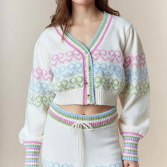 Pastel patterned cardigan worn by a person on a beige background