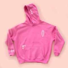 Pink hoodie with white designs on a pink background