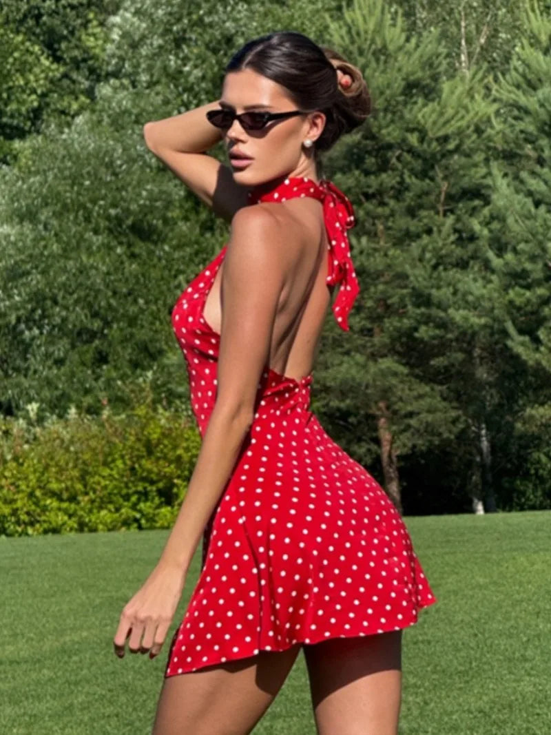 Woman wearing a red polka dot dress in an outdoor setting