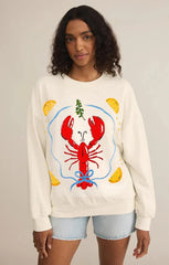 Person wearing a cream sweatshirt with a colorful lobster design