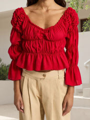 Red ruffled blouse worn by a person with a blurred background