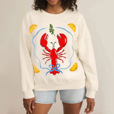 Person wearing a cream sweatshirt with a red lobster design