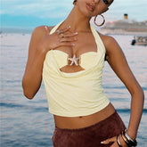 Woman wearing a yellow top with a starfish design by the water