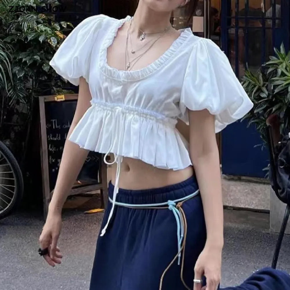 Woman wearing a white top and navy pants outdoors