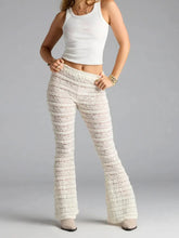 Person wearing textured white pants and a white top