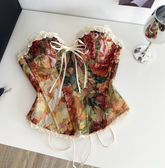 Floral corset on a white surface with sunglasses and a Chanel bag in the background