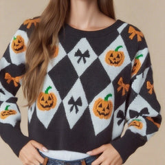 Person wearing a Halloween-themed sweater with pumpkins and bows