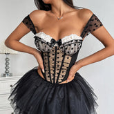 Black corset with sheer sleeves and lace details worn by a model against a white background