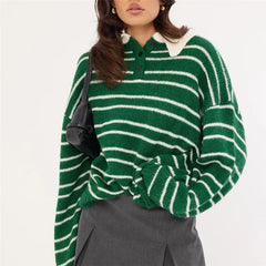 Person wearing a green and white striped sweater with a black bag on a white background