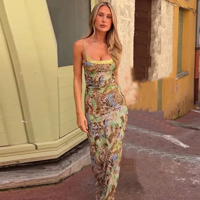 Woman in a patterned dress standing on a street with a building in the background