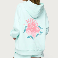 Light blue hoodie with floral design and text on the back against a light pink background