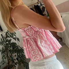 Woman wearing a pink and white patterned top in an indoor setting