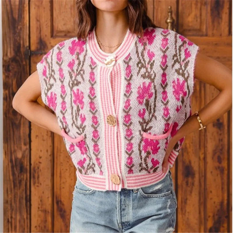 Person wearing a patterned pink and white sleeveless top against a wooden background
