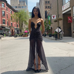 Woman in a black dress standing on a city street with buildings and trees in the background