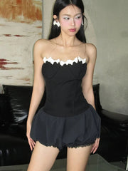 Woman wearing a black dress with white trim in an indoor setting