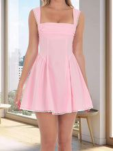 Pink dress with lace trim worn by a person in a bright room.