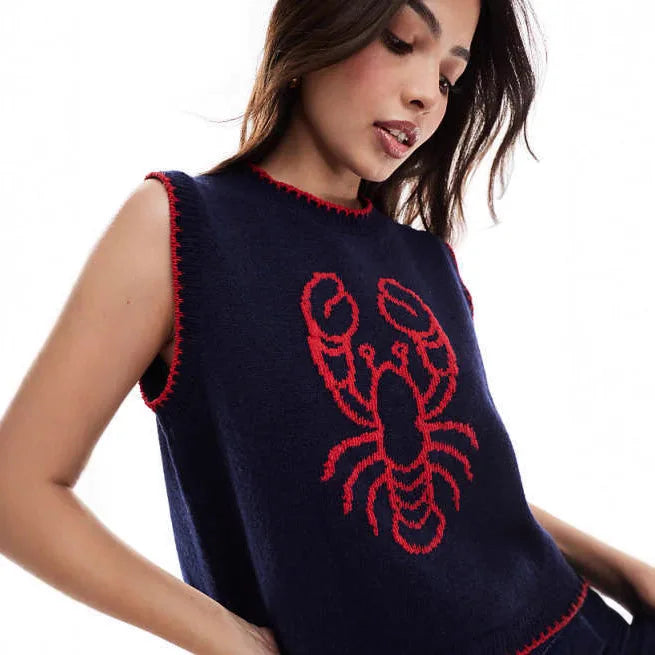 Woman wearing a navy blue sleeveless sweater with a red lobster design