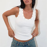 Woman wearing a white tank top with decorative buttons