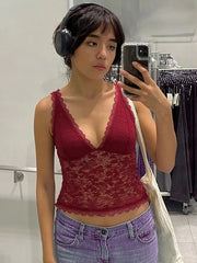 Person wearing a red lace top and blue jeans in a store setting.