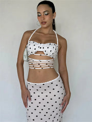 Woman wearing a polka dot top and skirt against a plain background