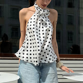 Woman wearing a white polka dot scarf with a blurred background