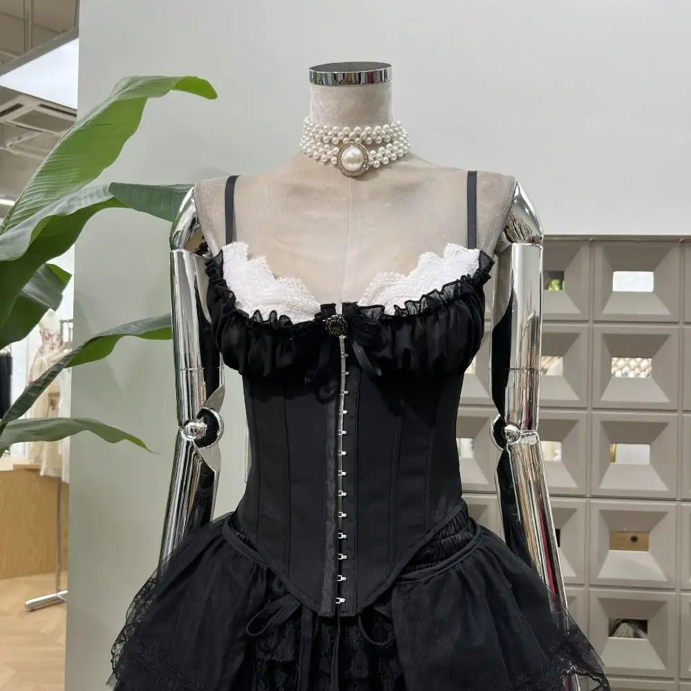 Black corset dress on a mannequin with pearl necklace, indoor setting