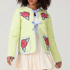 Light green quilted jacket with ice cream cone patches worn by a person on a plain background