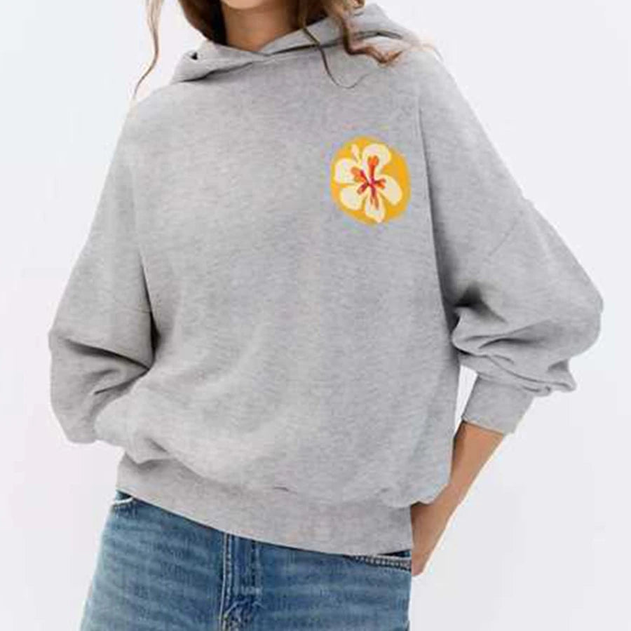 Person wearing a gray hoodie with a colorful flower design
