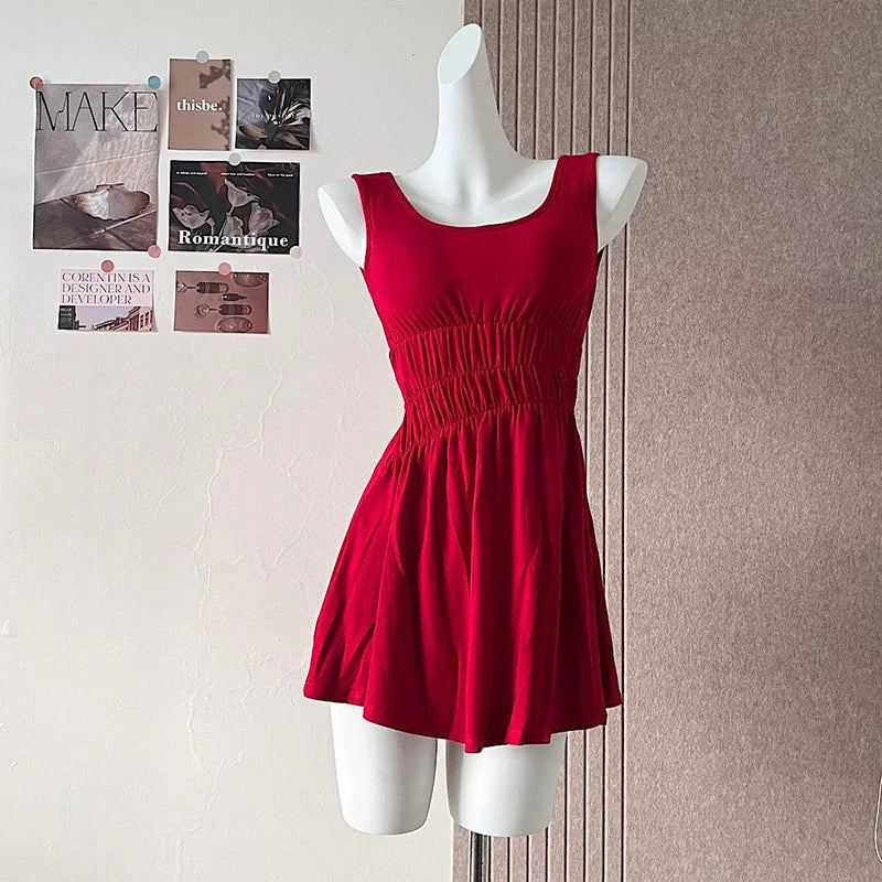 Red dress on a mannequin against a wall with pinned papers.
