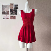 Red dress on a mannequin against a wall with pinned papers.