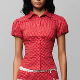 Women's polka dot button down lapel top with puff sleeves.
