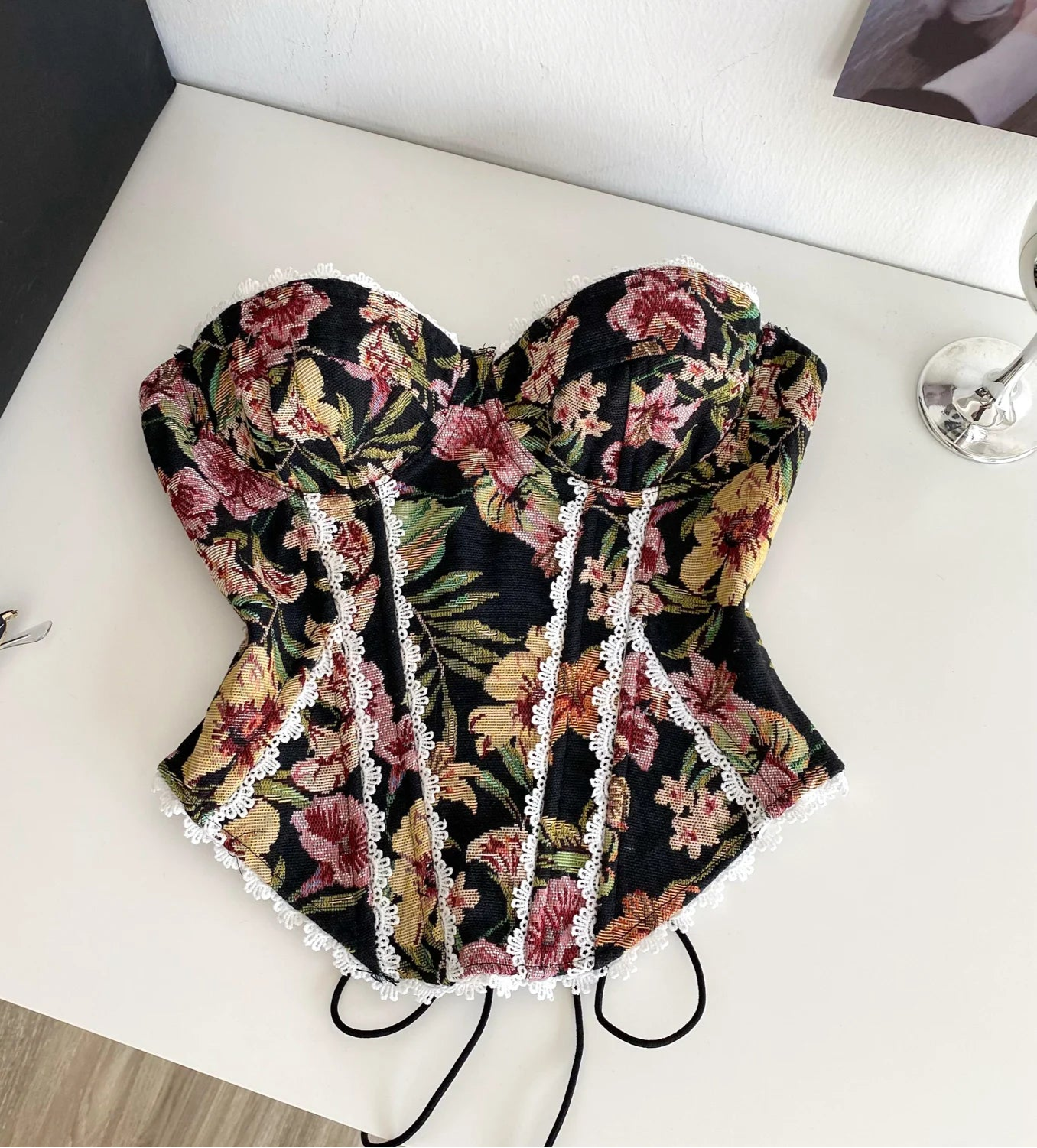 Floral corset with lace details on a white surface