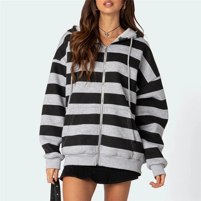 Black and gray striped hoodie worn by a model on a light blue background