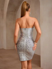 Woman wearing a silver strapless dress against a neutral background