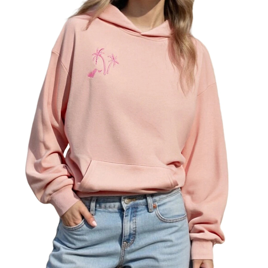 Person wearing a pink hoodie with palm tree design and light blue jeans