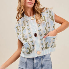 Woman wearing a floral patterned vest with a beige background
