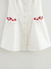 White blouse with floral embroidery on a light gray background