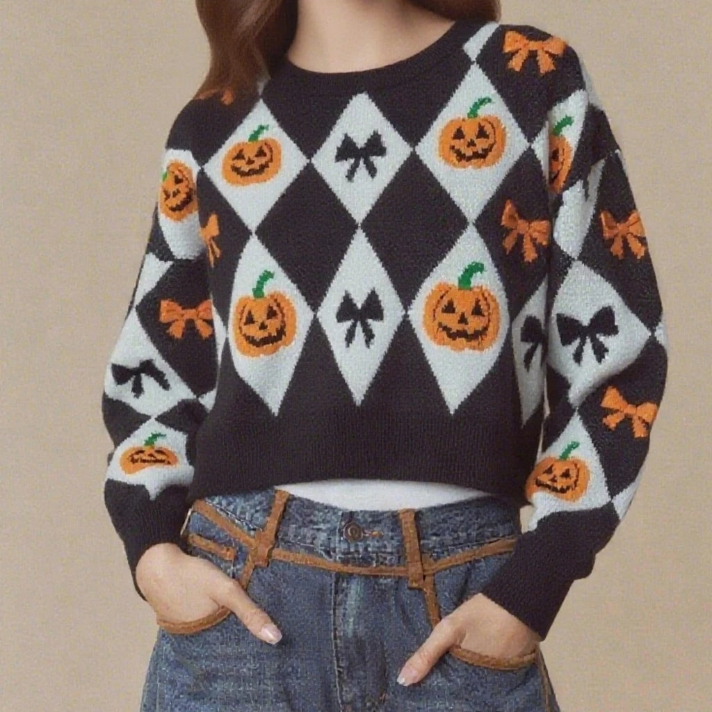 Person wearing a Halloween-themed sweater with pumpkins, bows, and zigzags