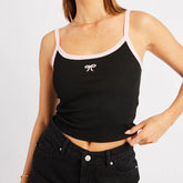 Black tank top with pink straps worn by a person on a plain background