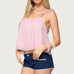 Woman wearing a pink top and denim shorts - side