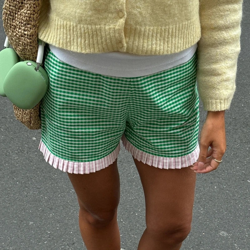 Women's charming green plaid shorts with ruffled hem.