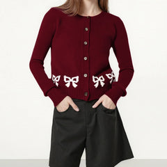 Red cardigan with white bow patterns worn by a person