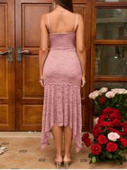 Woman wearing a pink lace dress standing next to a bouquet of flowers indoors.