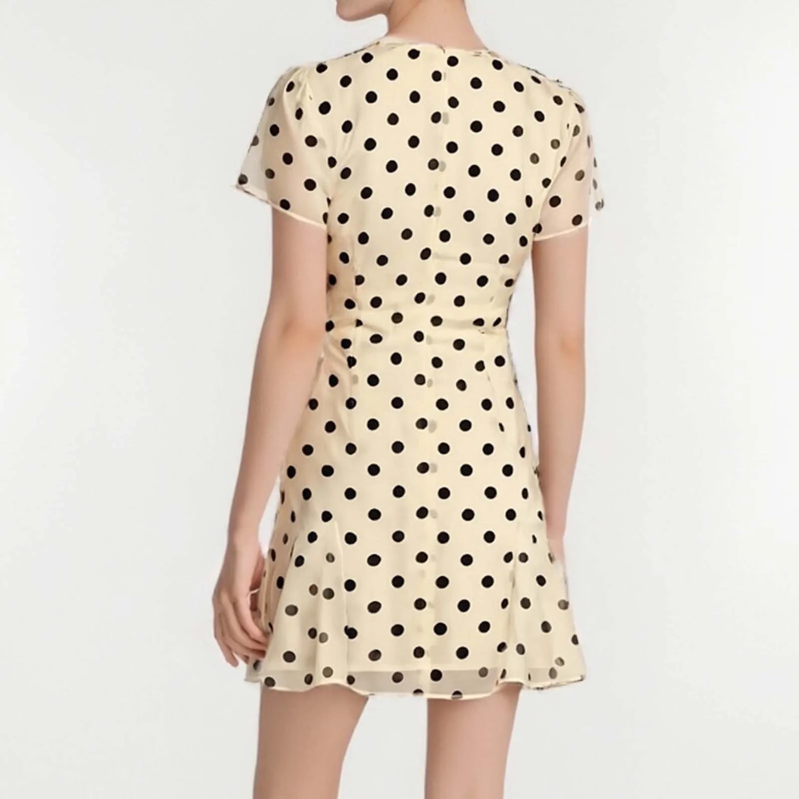 Beige dress with black polka dots on a white background