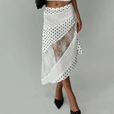 White lace skirt with black polka dots worn by a person on a gray background