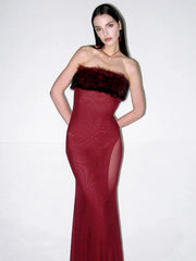 Woman wearing a burgundy evening gown with a fur-trimmed bodice